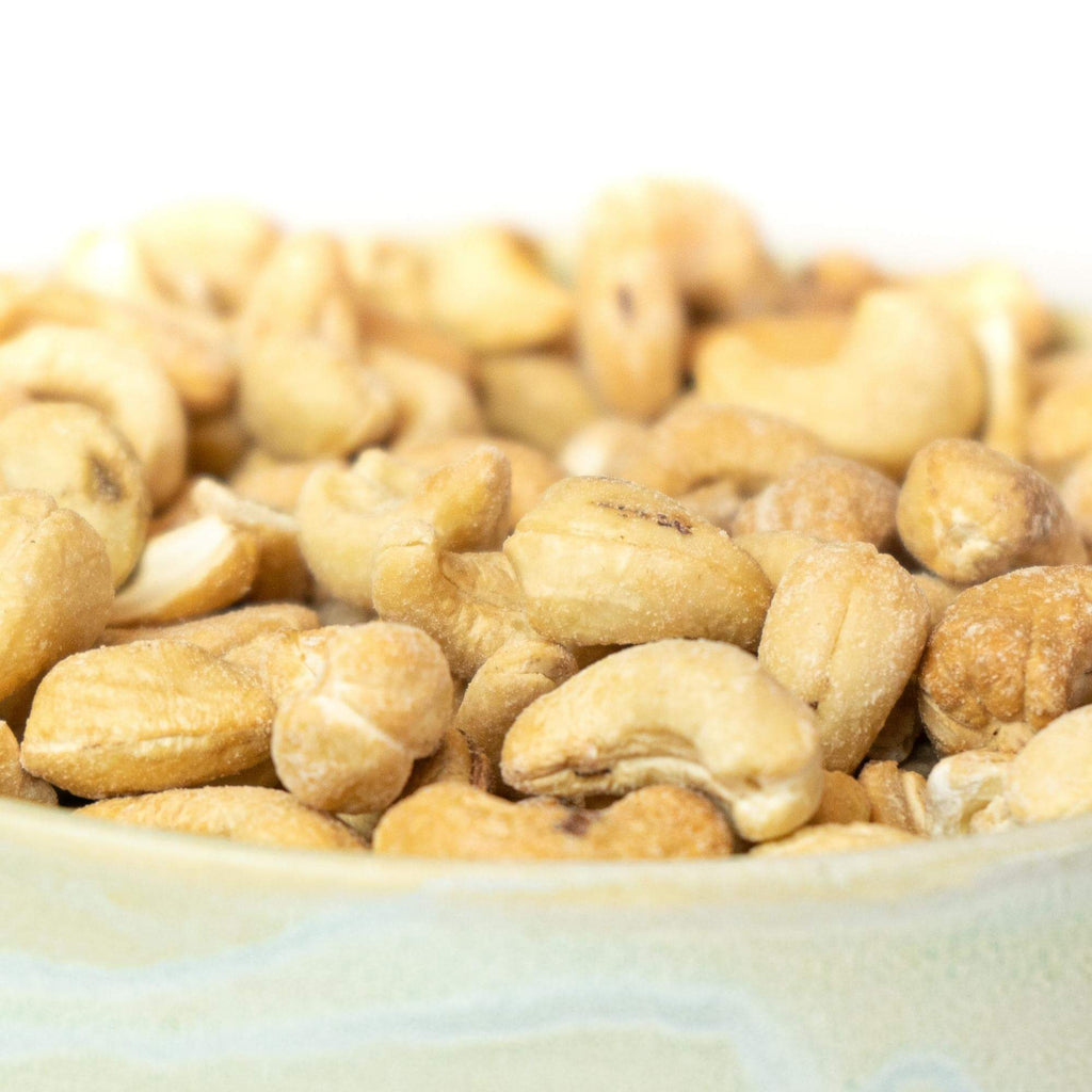 Ristede og letsaltede cashewnødder, billedet er med hvid baggrund taget fra siden, hvor der er zoomet ind på cashewnødderne.
