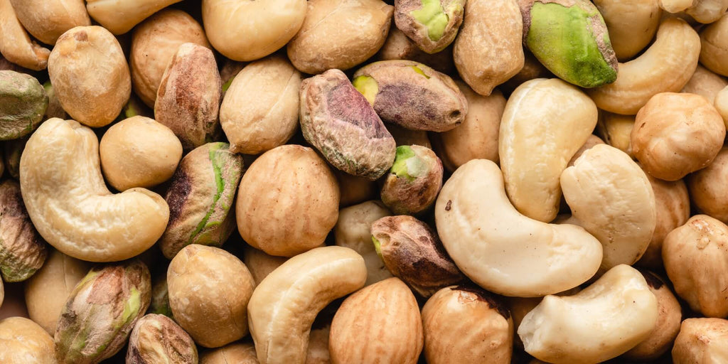  Blanding af økologiske og glutenfri nødder fra Danish Granola Company. Der er cashewnødder, pistacienødder og hasselnødder på billedet, blandet sammen.