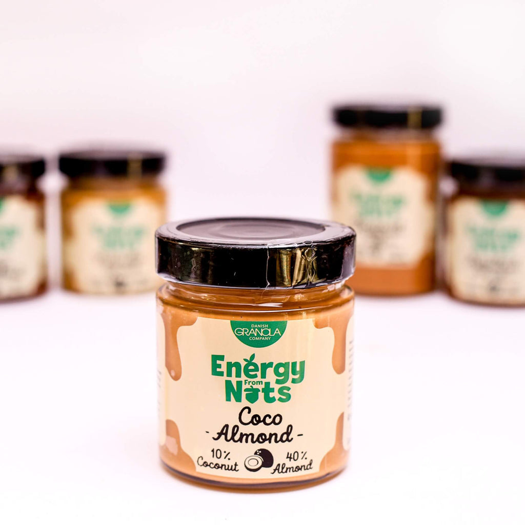ØKO Kokos & Mandler Smørpålæg fra Danish Granola Company fotograferet fra siden med andre smørpålæg i baggrunden