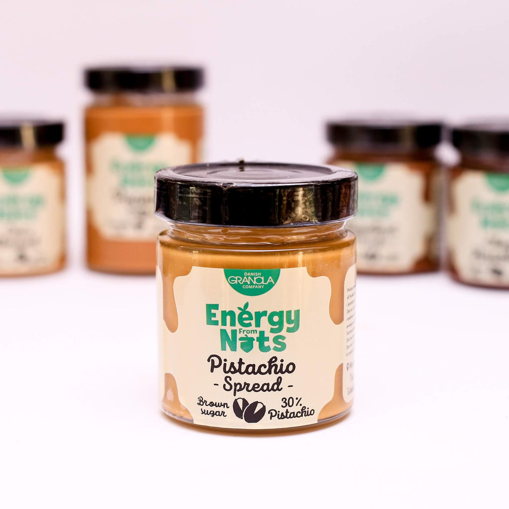 ØKO Pistacie Smørpålæg fra Danish Granola Company fotograferet fra siden med andre smørpålæg i baggrunden