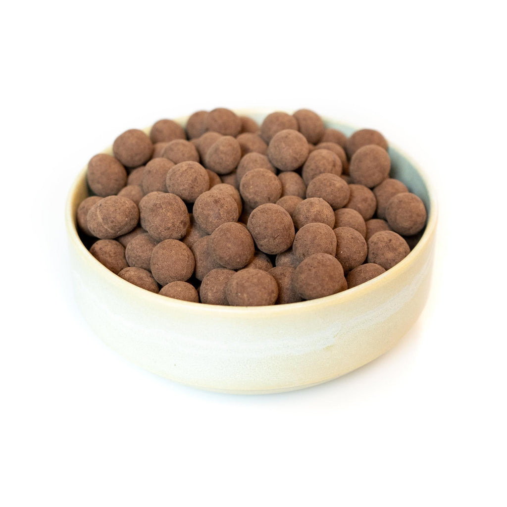 Mælkechokoladeovertrukket hasselnødder, billedet er med hvid baggrund taget fra siden.