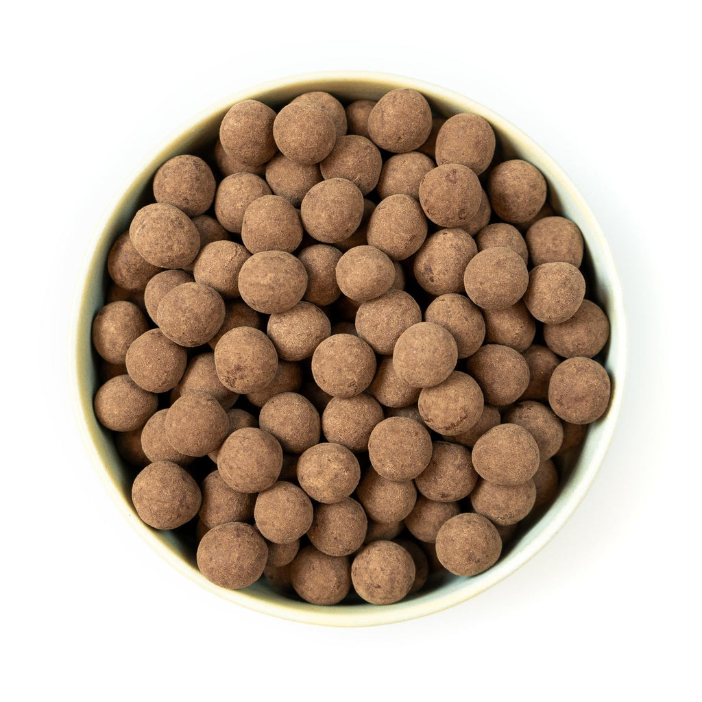 Mælkechokoladeovertrukket hasselnødder, billedet er med hvid baggrund taget ovenfra.
