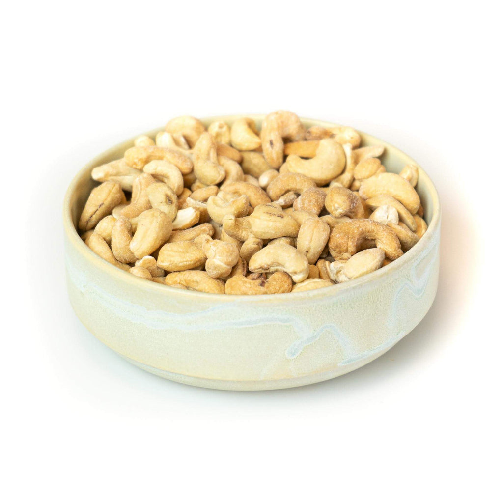 Ristede og letsaltede cashewnødder, billedet er med hvid baggrund taget fra siden.
