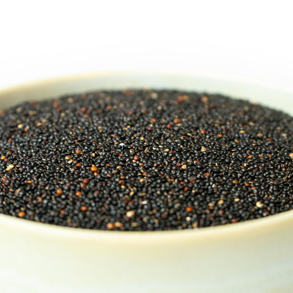 Sort quinoa, billedet er med hvid baggrund taget fra siden, hvor der er zoomet ind på quinoaen.